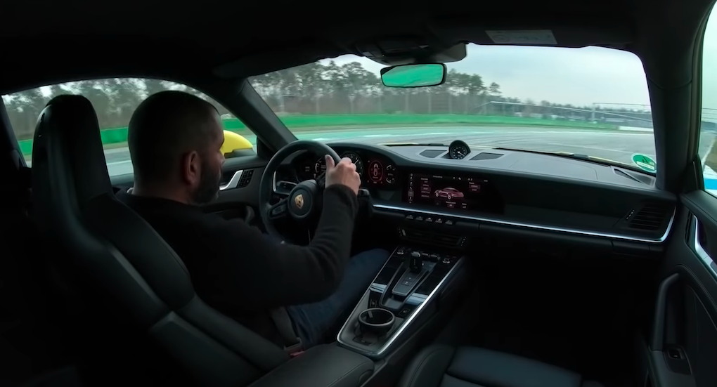 En man kör en bil på en racerbana. (AI text)