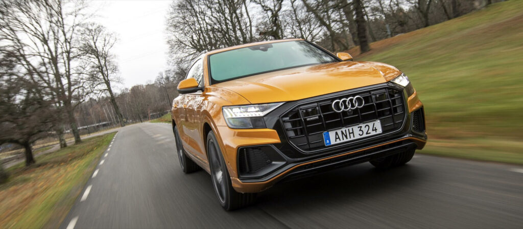 En Audi Q4 SUV kör längs en landsväg. (AI text)