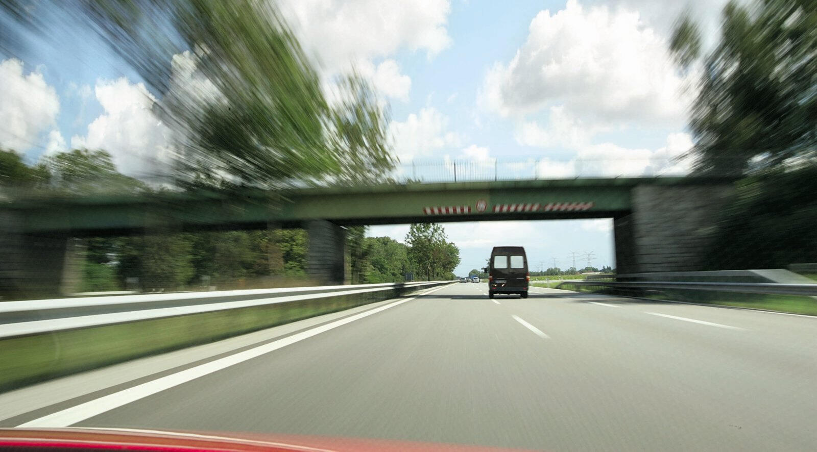 En bil kör nerför en väg. (AI text)