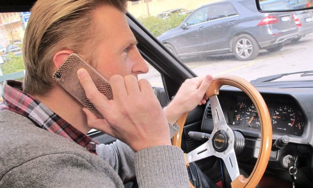 En man kör bil medan han pratar på telefonen. (AI text)