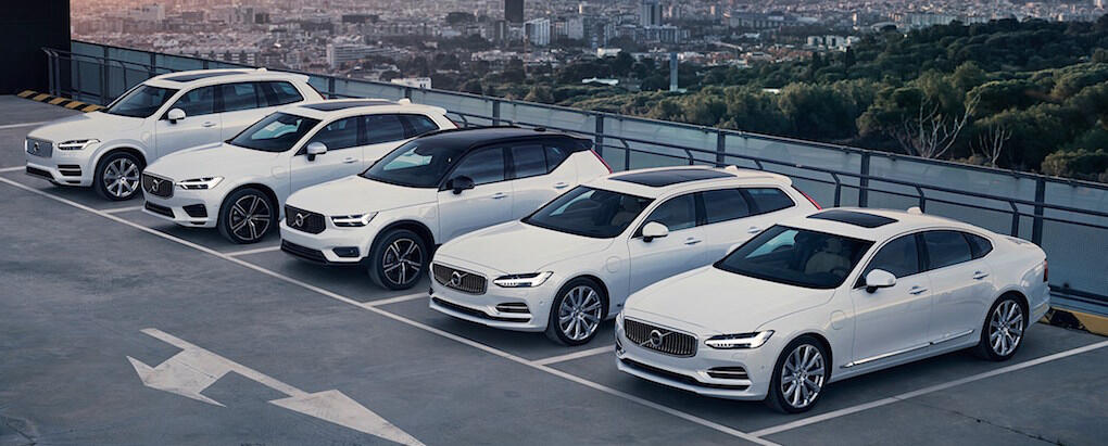 En rad vita Volvo bilar parkerade i en parkeringsplats. (AI text)