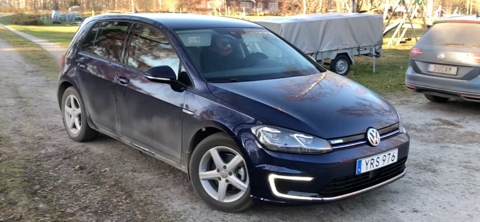 En Volkswagen Golf parkerad på en grusväg. (AI text)