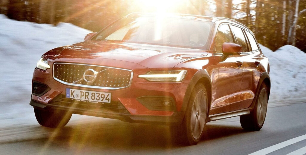 En röd Volvo XC90 SUV kör nerför en snöig väg. (AI text)