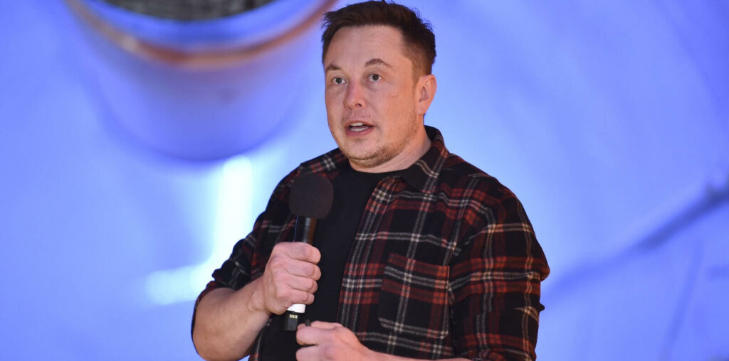 En man talar på scenen vid ett evenemang. (AI text)