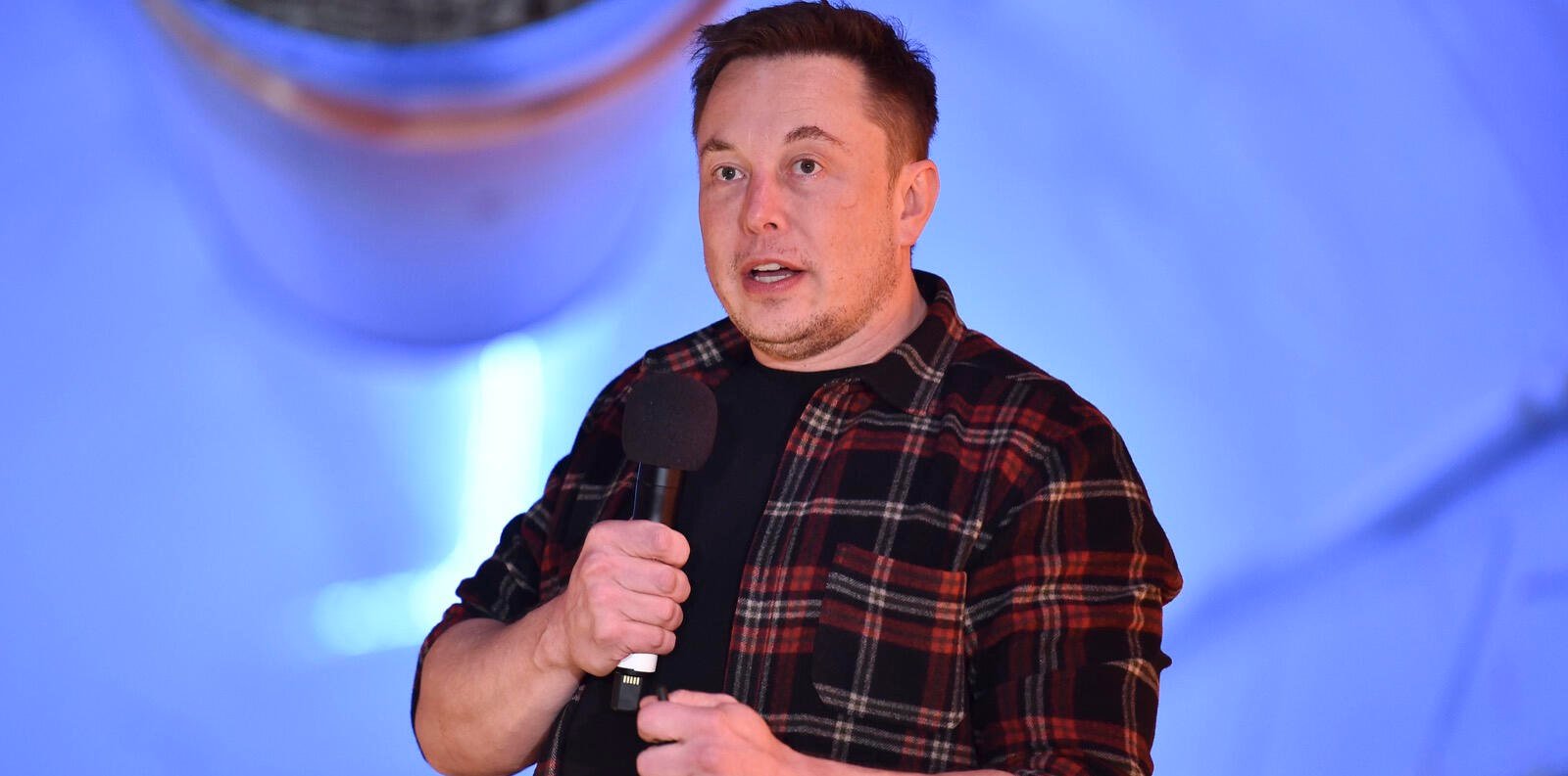 En man talar på scenen vid ett evenemang. (AI text)