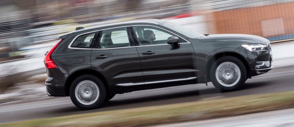 En Volvo XC90 SUV kör ner en gata. (AI text)