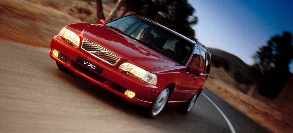 En röd bil kör längs en landsväg. (AI text)