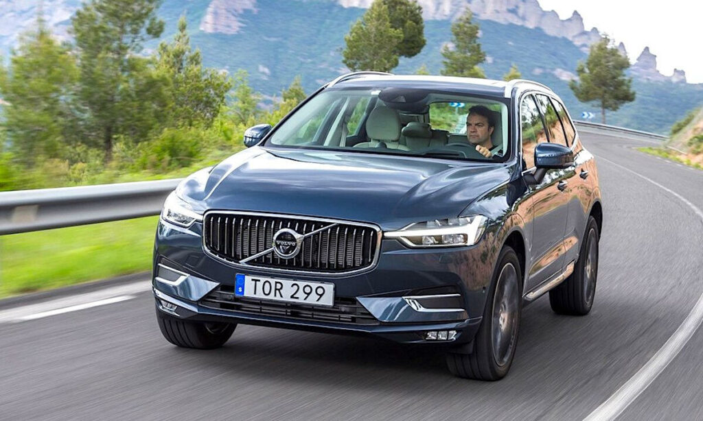 Volvo XC90 SUV kör nerför en bergsväg. (AI text)