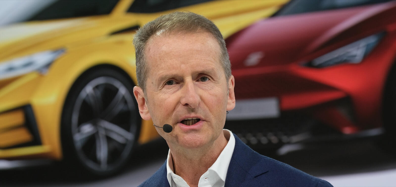 En man talar till en grupp bilar. (AI text)