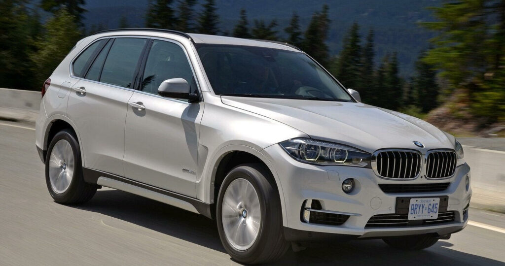 BMW X5 kör på en bergsvidja. (AI text)