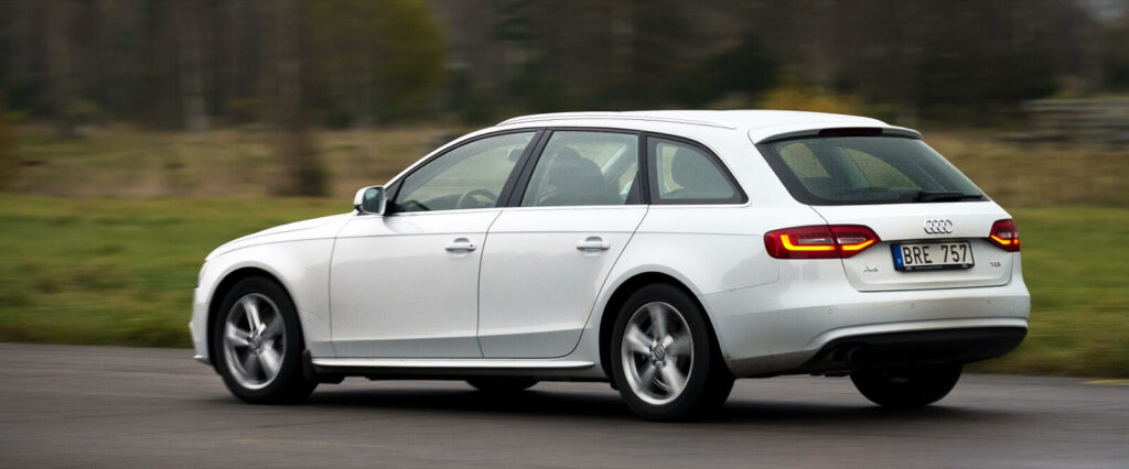 En Audi A4 kombi kör längs en landsväg. (AI text)