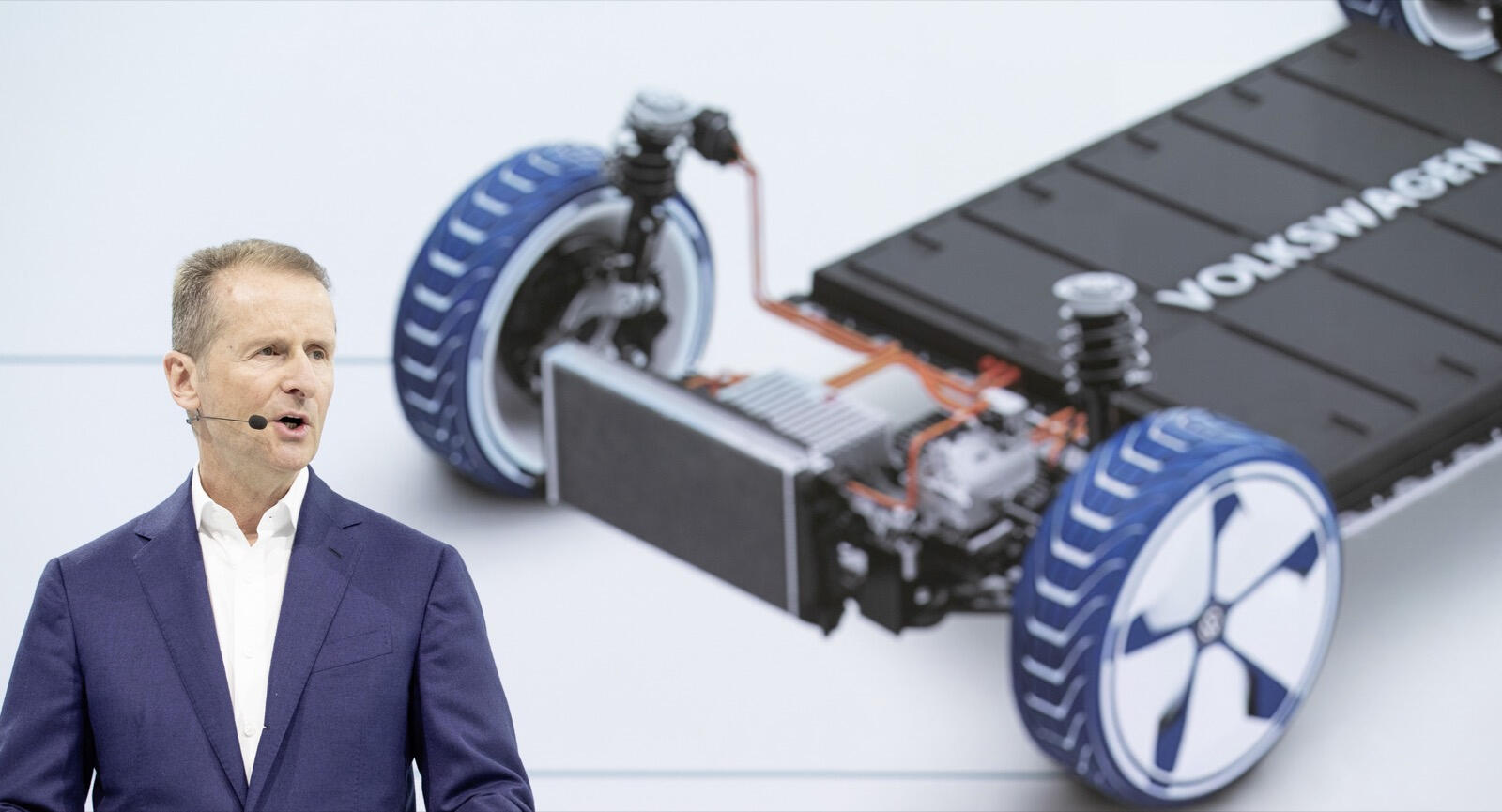 En man står framför en bil med en batteri monterat på den. (AI text)