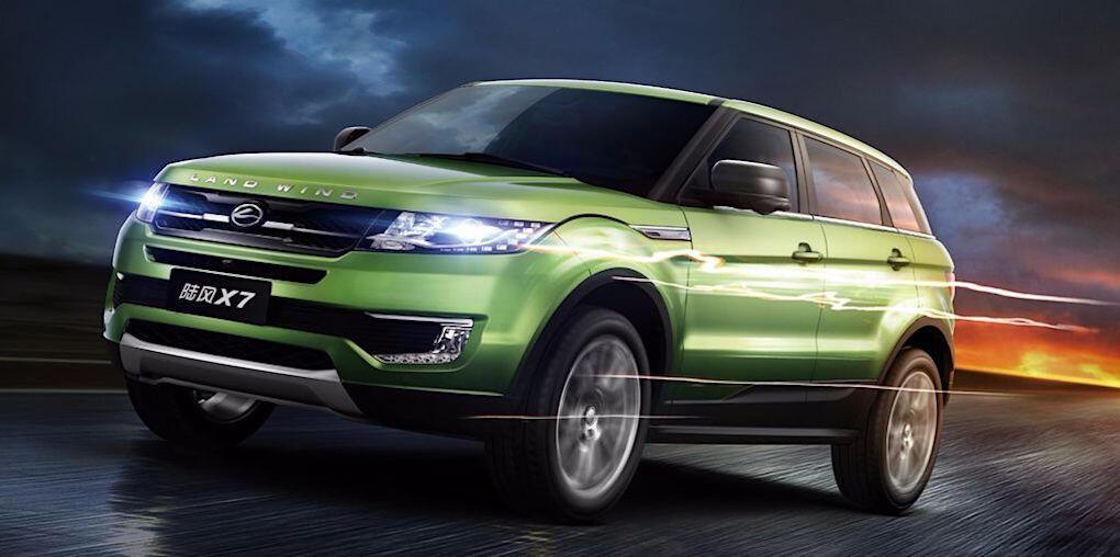 En grön SUV kör på en väg med en mörk himmel bakom den. (AI text)