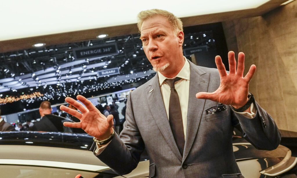 En man i kostym pratar med en annan man i kostym. (AI text)