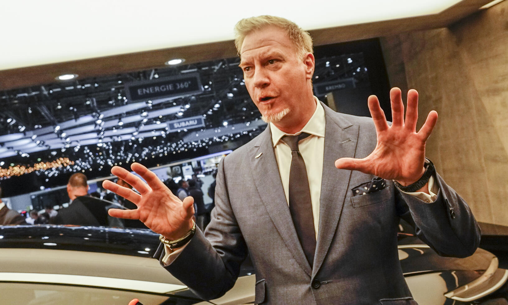 En man i kostym pratar med en annan man i kostym. (AI text)