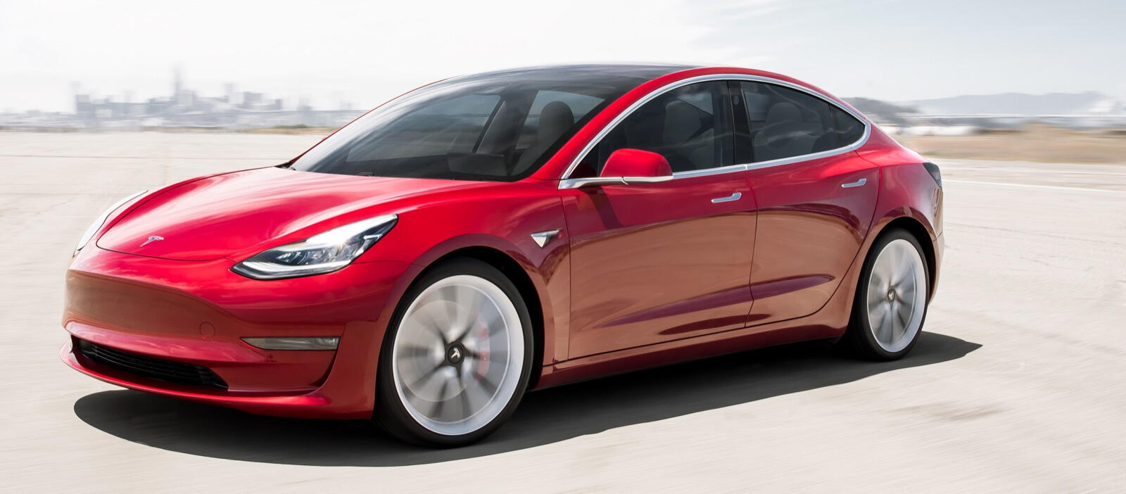 En Tesla Model 3 kör på en ökenväg. (AI text)