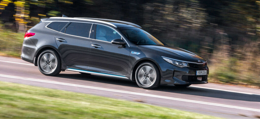 Kia Optima kör längs en landsväg. (AI text)