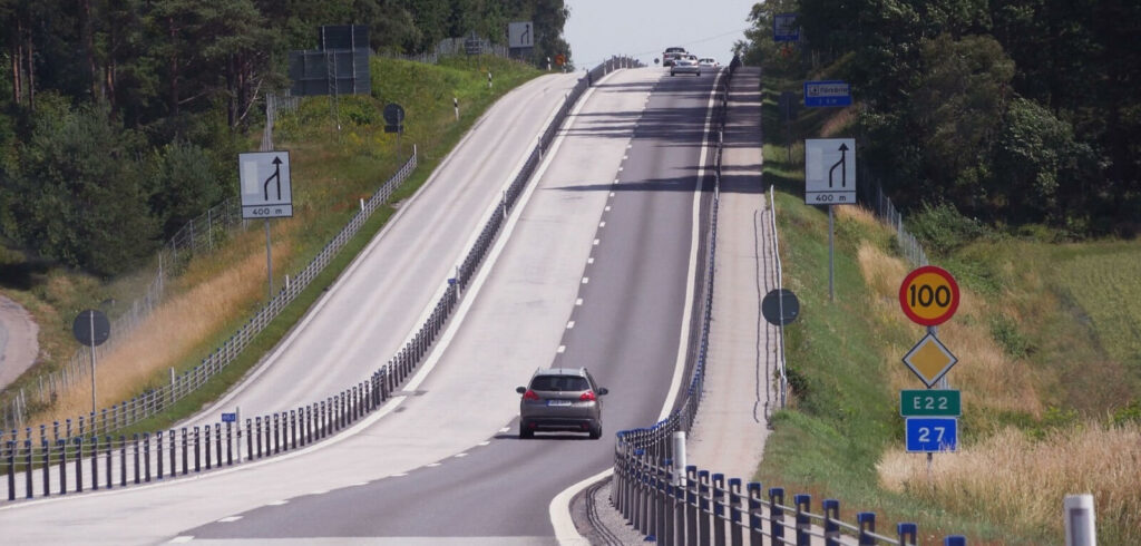 En bil kör nedför en motorväg. (AI text)