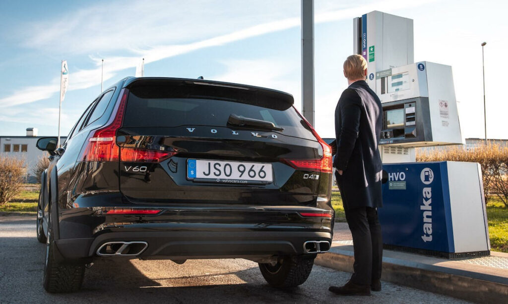 En man står bredvid en bil vid en bensinstation. (AI text)