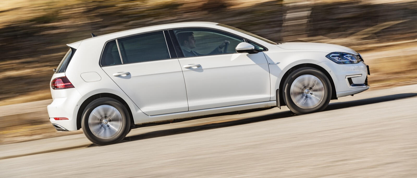 Volkswagen Golf e GTI kör längs en landsväg. (AI text)