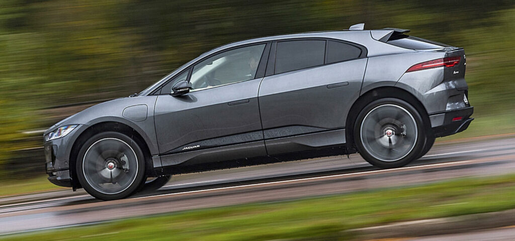 En Jaguar I Pace kör längs en väg. (AI text)