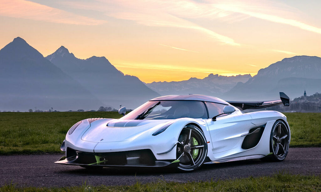 En vit sportbil parkerad vid en väg i bergen. (AI text)