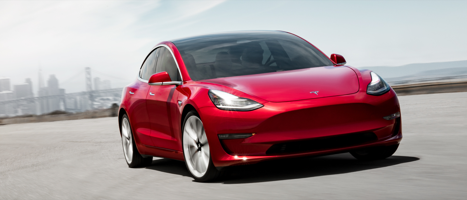 En Tesla Model 3 kör på en stadsgata. (AI text)