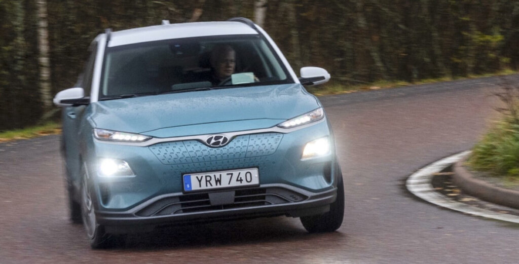 En blå Hyundai EV kör nerför en krävande väg. (AI text)