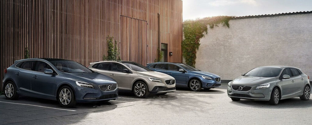 En grupp bilar parkerade framför ett byggnad. (AI text)