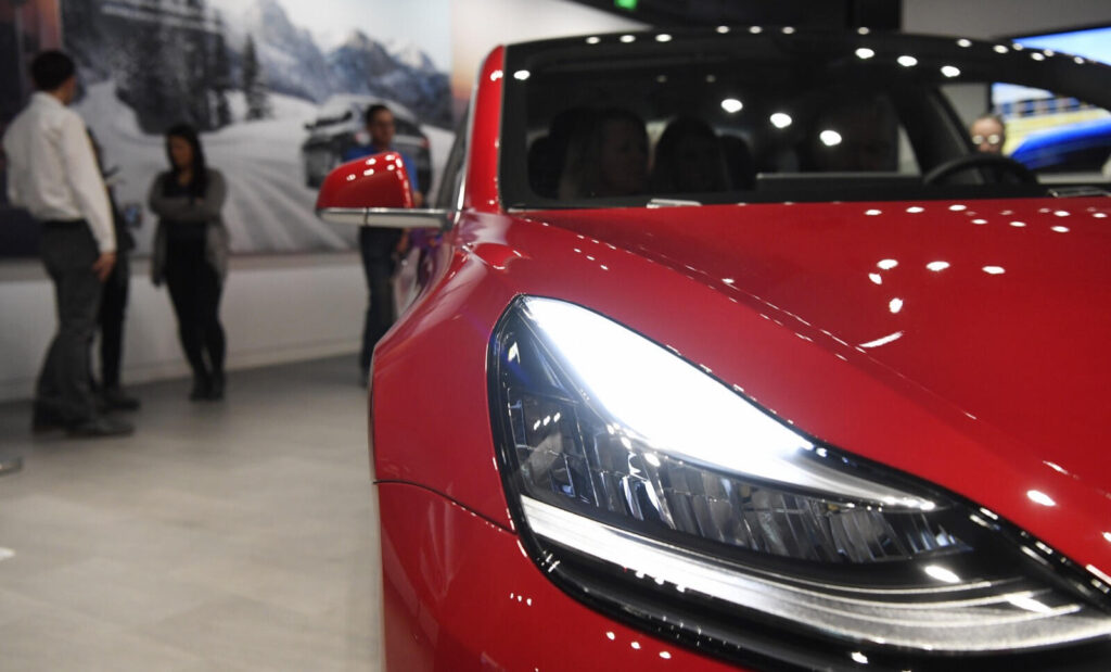 Tesla Model 3 utställd på Shanghais bilmesse - fotografi från Reuters (AI text)