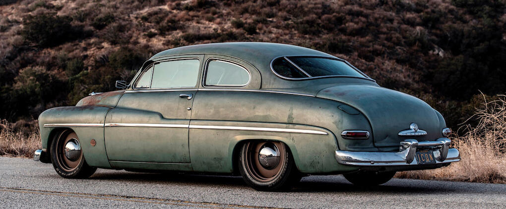 En klassisk bil parkerad vid vägkanten. (AI text)