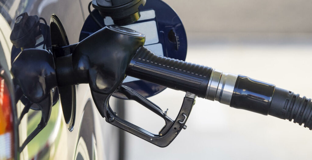 En bil fyller på med bränsle på en bensinstation. (AI text)