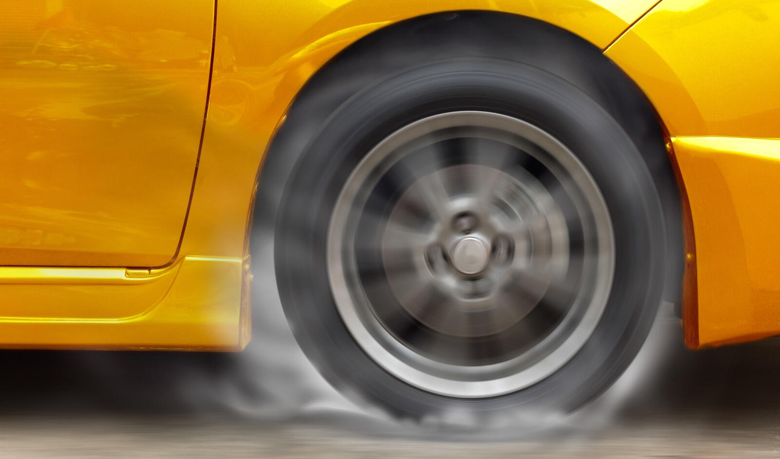 En gul sportbil kör på en gata. (AI text)