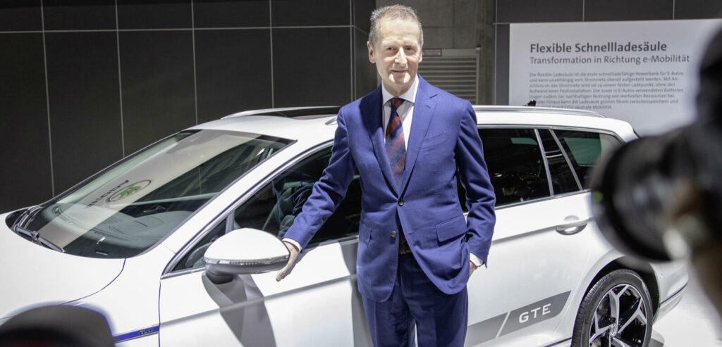 En man i kostym står bredvid en bil. (AI text)