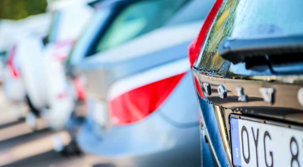 En rad bilar parkerade i en parkeringsplats. (AI text)