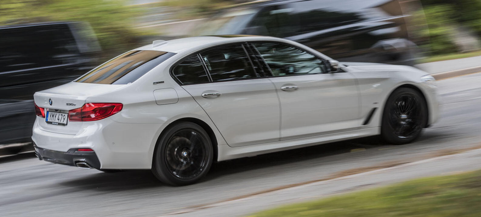 BMW M5 sedan kör längs gatan (AI text)