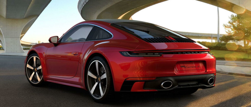 En röd Porsche 911 GTS kör ner en gata. (AI text)