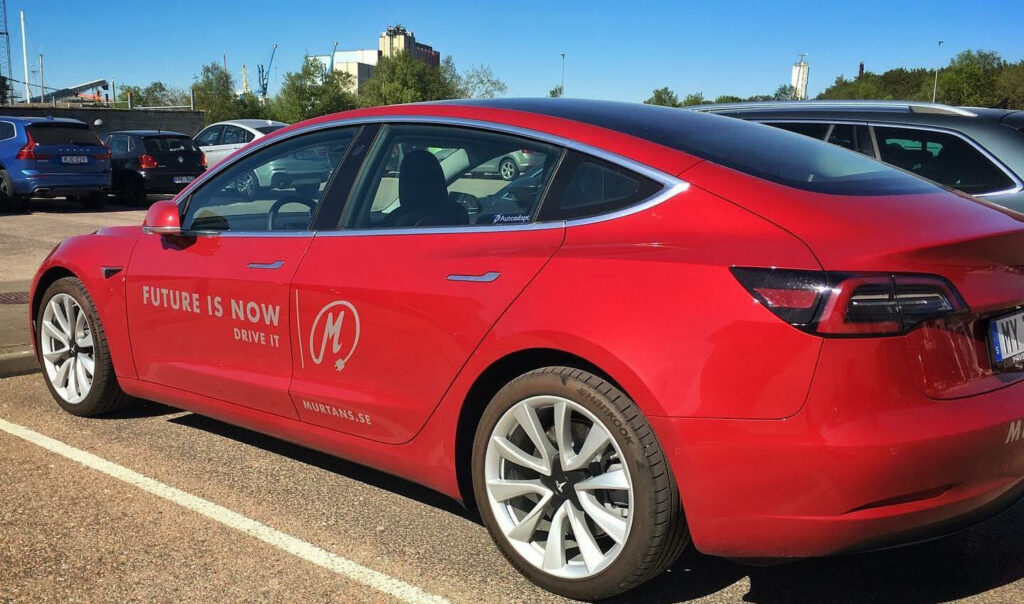 Tesla Model 3 parkerad i garage. (AI text)