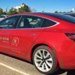 Tesla Model 3 parkerad i garage. (AI text)