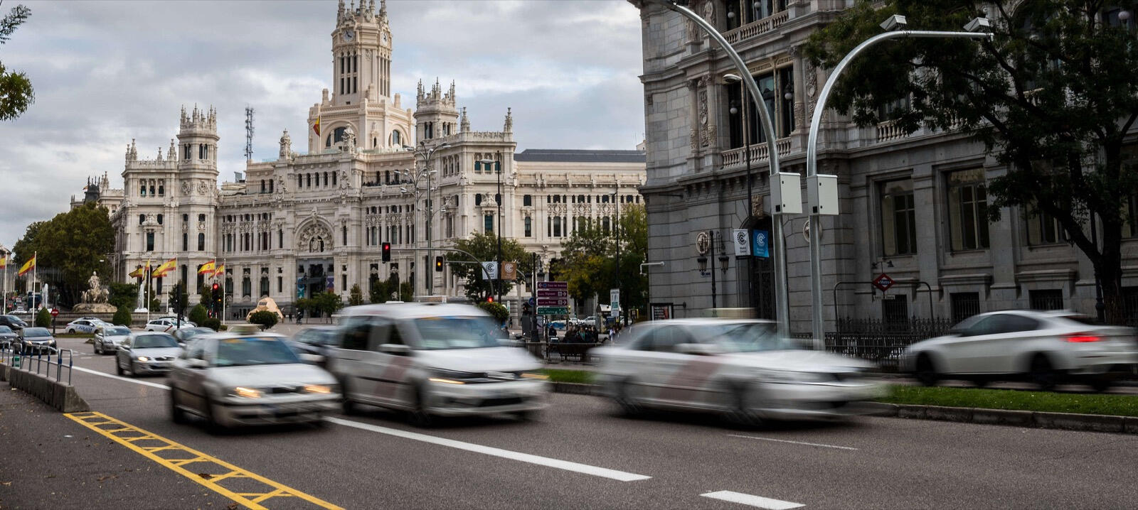 En stadsgata med bilar som kör längs den (AI text)