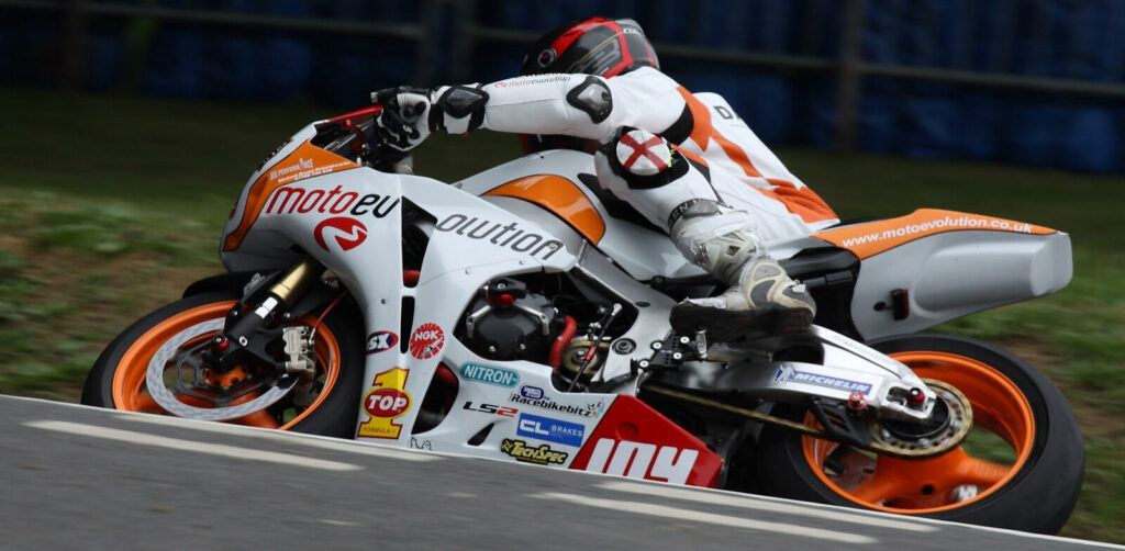 En motorcykelpilott kör på en banan. (AI text)