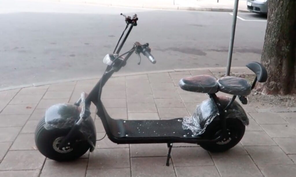 En scooterparkerad på trottoaren (AI text)