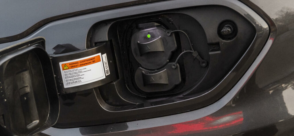 En bil är uppkopplad till en el-laddare. (AI text)