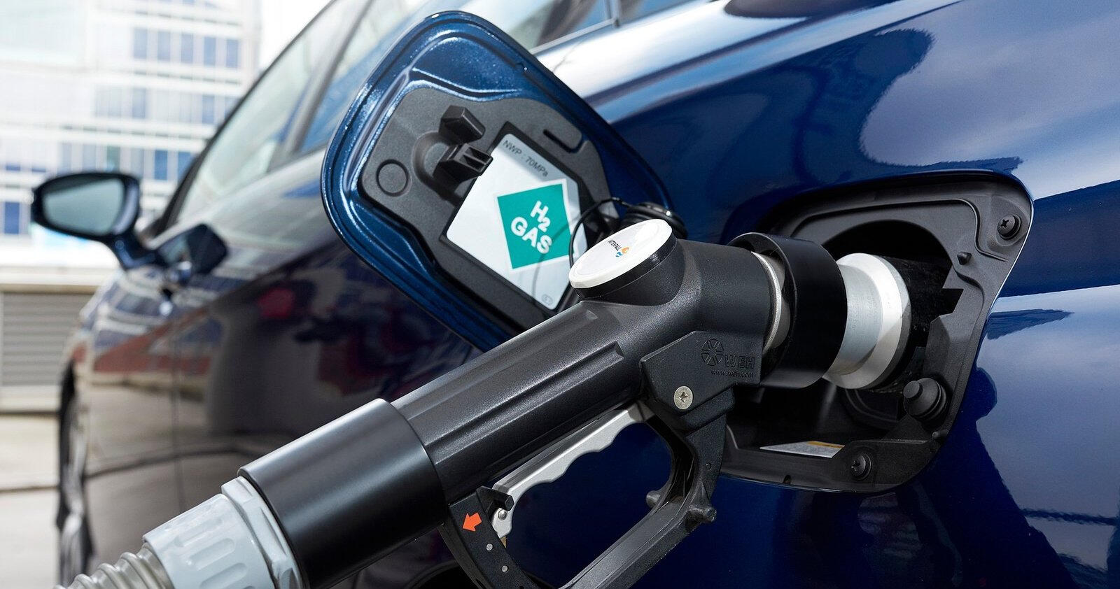 En blå bil tankar med gasol. (AI text)