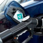 En blå bil tankar upp med bensin. (AI text)