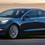 Tesla Model 3 kör på en bergsväg. (AI text)