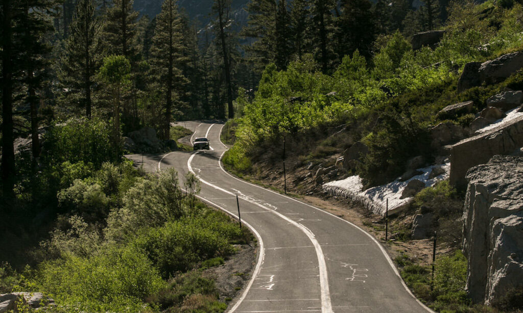 En bil kör nerför en bergsväg. (AI text)