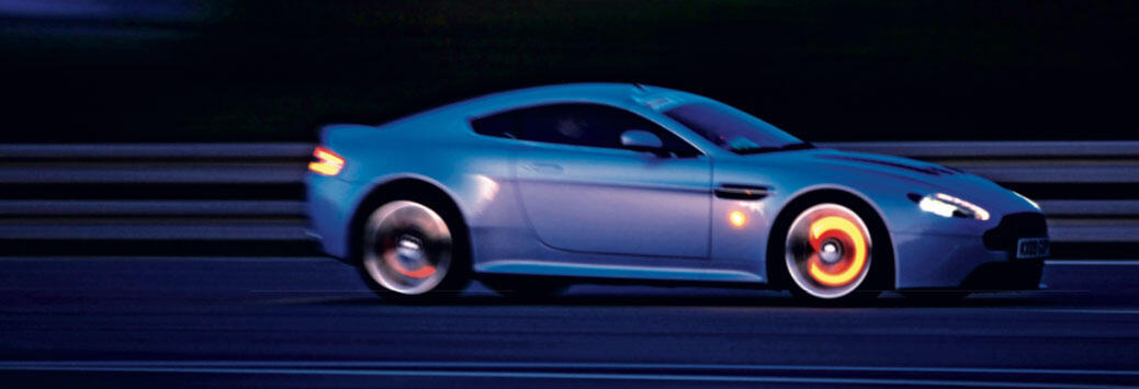 Aston Martin Vantage V12 kör på vägen (AI text)