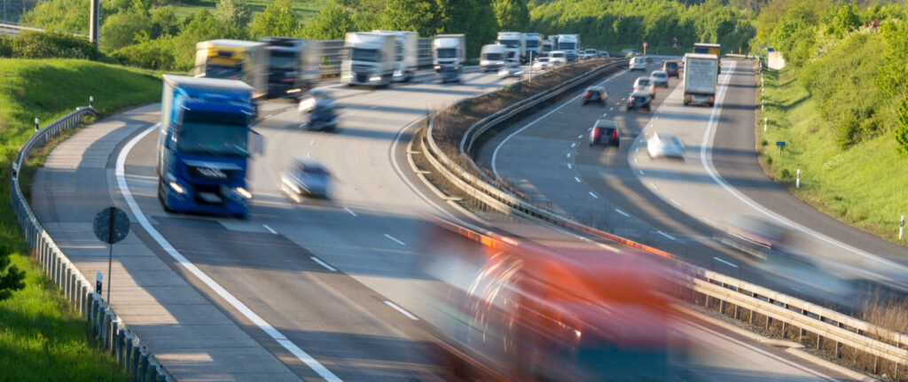 En suddig bild av en väg med bilar och lastbilar. (AI text)