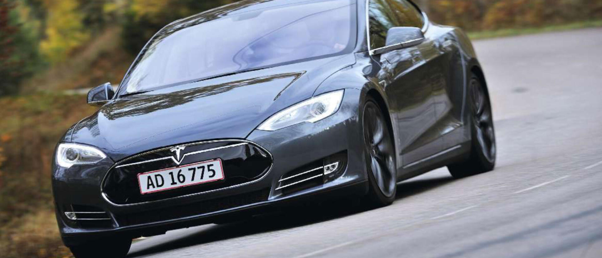 Tesla Model S kör längs en landsväg. (AI text)